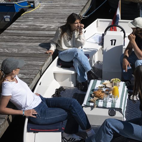 Mensen zitten in bootje aan de kade in Amsterdam