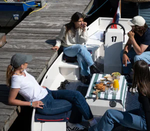 Mensen zitten in bootje aan de kade in Amsterdam